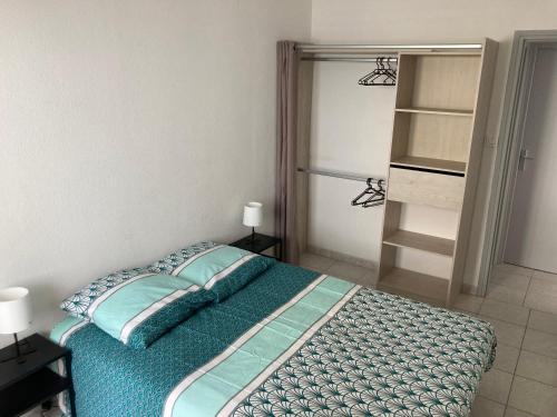 - une chambre avec un lit doté de draps et d'oreillers bleus dans l'établissement Le Petit Large T2 - vue sur mer, à Saint-Hilaire-de-Riez