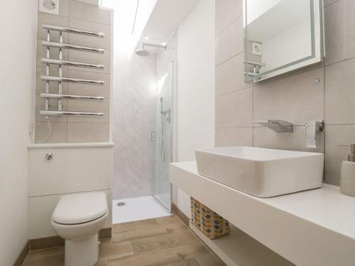 a white bathroom with a sink and a toilet at Bumble Bee Retreat in Axminster