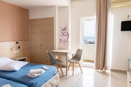 una camera d'albergo con letto, tavolo e sedie di Achilleas Hotel Apartments a Città di Kos