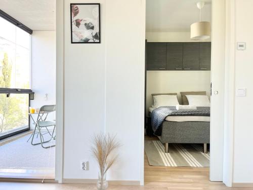 um quarto com uma cama e um quarto com uma janela em Tammer Huoneistot - City Suite 5 - Own Sauna, Balcony & Best Location em Tampere