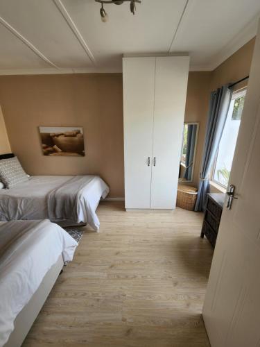 a bedroom with two beds and a closet at Jenvey House Selfcatering Apartments & BnB in Port Elizabeth