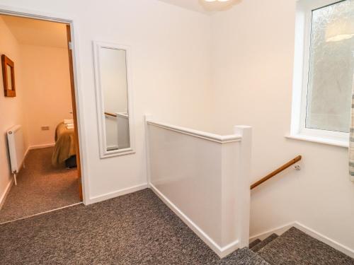 a hallway with a white door and a mirror at Delabere Road in Bishops Cleeve