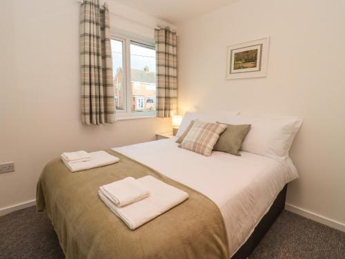 a bedroom with a large bed with two towels on it at Delabere Road in Bishops Cleeve