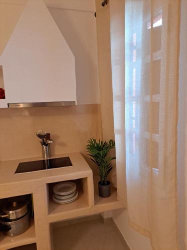 eine Küche mit einem Waschbecken und einem Fenster in einem Zimmer in der Unterkunft Studios Irineos in Perissa