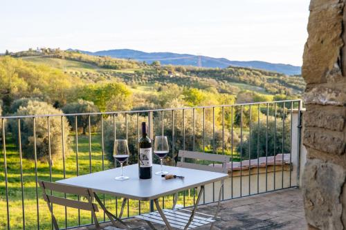 a white table with two glasses of wine on a balcony at Podere Montale Il Borgo in Seggiano