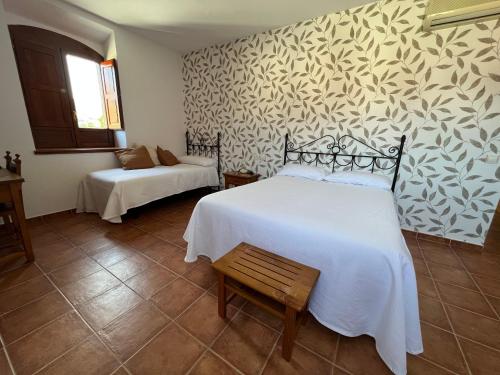 een slaapkamer met 2 bedden en een muurschildering bij Hostal Villa el Colmenar in Mombeltrán