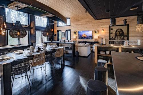 a restaurant with tables and chairs in a room at Chalet TIPI, Chic Charme & Nature in La Malbaie