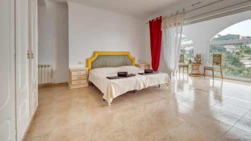 a bedroom with a bed and a large window at Costacabana - Villa Sunrise in Lloret de Mar