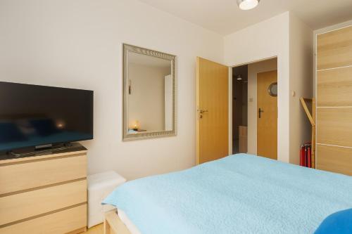 a bedroom with a bed and a flat screen tv at Golden Dune 100m od plaży in Międzyzdroje