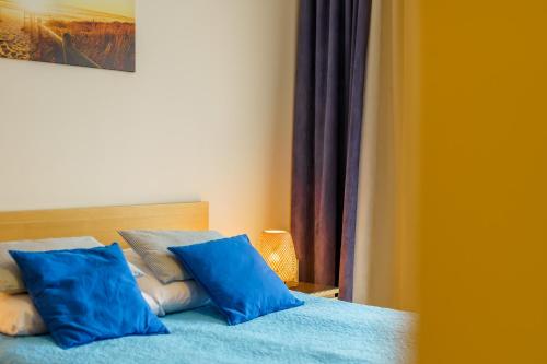 a blue bed with two blue pillows on it at Golden Dune 100m od plaży in Międzyzdroje
