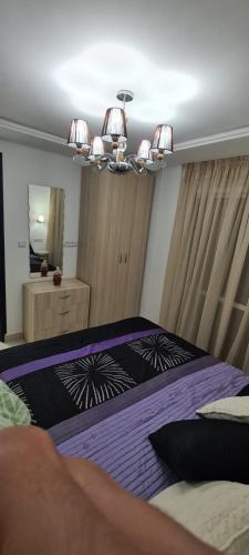 a bedroom with a bed with purple sheets and a mirror at Espacioso Arrissala in Nador