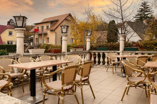 - un ensemble de tables et de chaises sur une terrasse dans l'établissement Hegyalja Étterem és Panzió, à Zsámbék