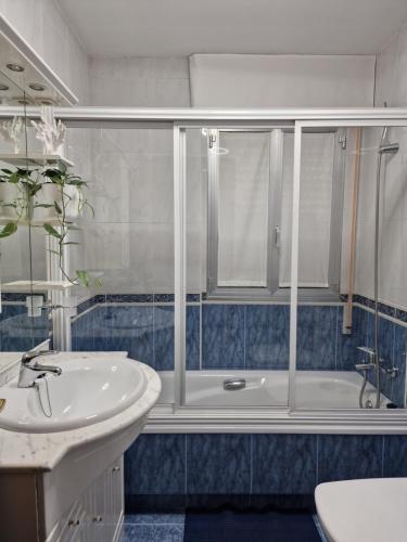 Apartamento Raxobrisamar في راكسو: حمام مع دش ومغسلة وحوض استحمام