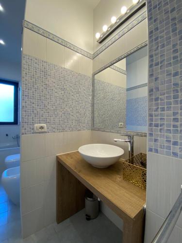 un baño con lavabo y espejo en Caserta Royale Family, en Coccagna
