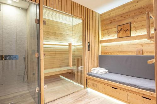 una sauna con banco y ducha en Chalet Lumière - LaGodille Prestige - 16 personnes - Pra Loup, en Uvernet