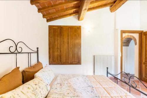 um quarto com uma cama e um tecto de madeira em Olive House Tuscany em Calci