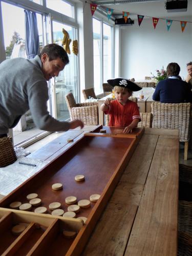 a man and a little boy playing a board game at De Slaapfabriek vakantiehuis en trainingslocatie in Teuge