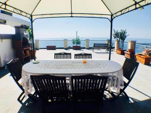 een tafel en stoelen op een patio met uitzicht op de oceaan bij Riviera Mare in Varazze