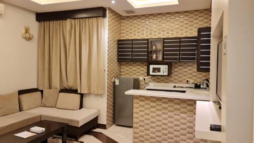 Dana Park في الرياض: غرفة معيشة مع أريكة ومطبخ
