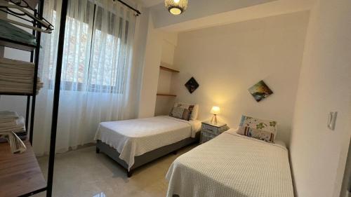 1 Schlafzimmer mit 2 Betten und einem Fenster in der Unterkunft Ozy Apart Garden / Kaş-Çerçiler in Kaş