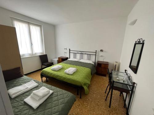 1 Schlafzimmer mit 2 Betten und einem Spiegel in der Unterkunft YOLO Rooms in Bonassola