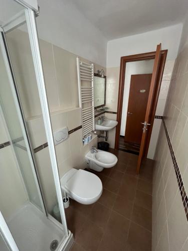 ein Badezimmer mit 2 WCs und einer Dusche in der Unterkunft YOLO Rooms in Bonassola