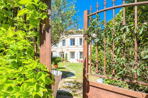 a wooden gate to a garden with a house in the background at Bastide les Oréades - Villa de luxe in Marseille