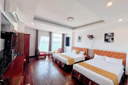 Habitación de hotel con 2 camas y TV en Catinal Hotel, en Da Nang