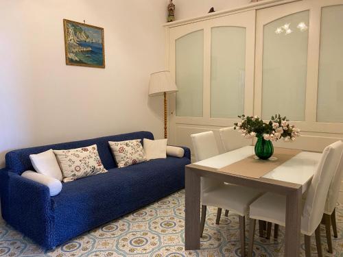Capri Suite Dreams في كابري: غرفة معيشة مع أريكة زرقاء وطاولة