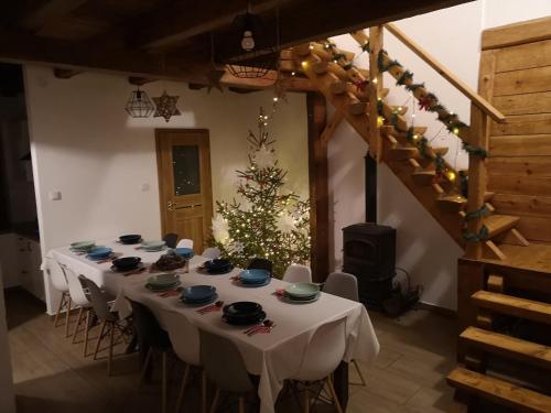 a room with a table with a christmas tree in it at Osada na Granicy - Domki w Bieszczadach in Ustrzyki Dolne