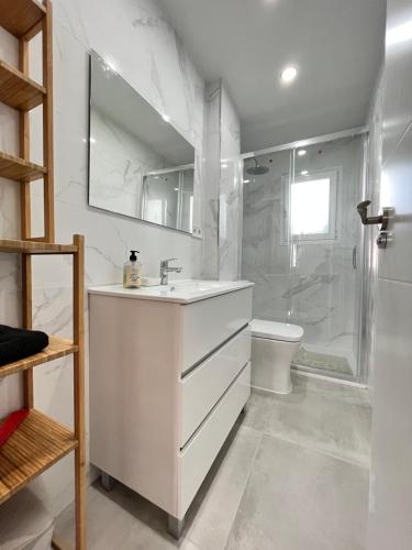 biała łazienka z umywalką i prysznicem w obiekcie Gran Piso Retiro Corregidor w Madrycie
