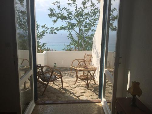 an open door to a patio with chairs and tables at Residenza Gherly in Capo Vaticano