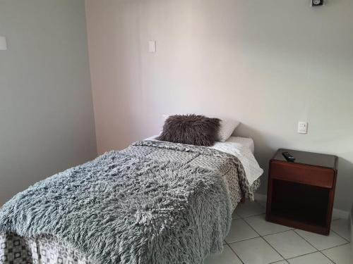 a bedroom with a bed with a gray comforter at HABITACION BAÑO COMPARTIDO in Copiapó