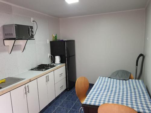 a kitchen with a table and a microwave and a refrigerator at HABITACION BAÑO COMPARTIDO in Copiapó
