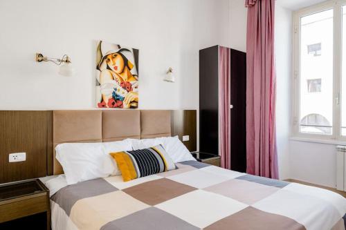 a bedroom with a bed with a checkerboard patterned bedspread at Francesco Romestay - Termini in Rome