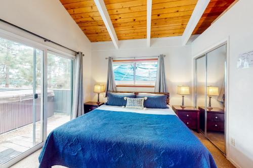 a bedroom with a blue bed and a window at Saddle Road Sanctuary in South Lake Tahoe