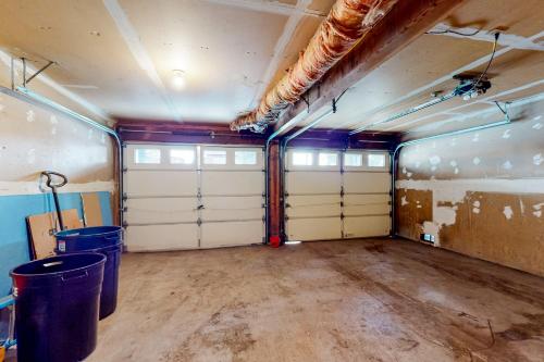 an empty garage with two garage doors and two trash cans at Saddle Road Sanctuary in South Lake Tahoe