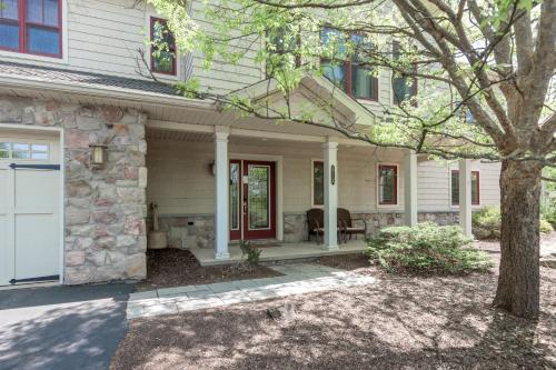 a house with a white door and a tree at 6 Fieldstone Ct in Lake Harmony