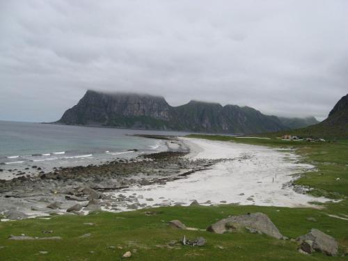 une plage sur la côte avec des montagnes en arrière-plan dans l'établissement Room in house on the road to Lofoten, à Harstad
