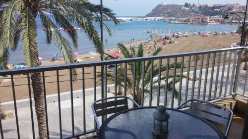 balcón con mesa y sillas y playa en BAHIA MAZARRON apartamento en primera linea playa, en Puerto de Mazarrón