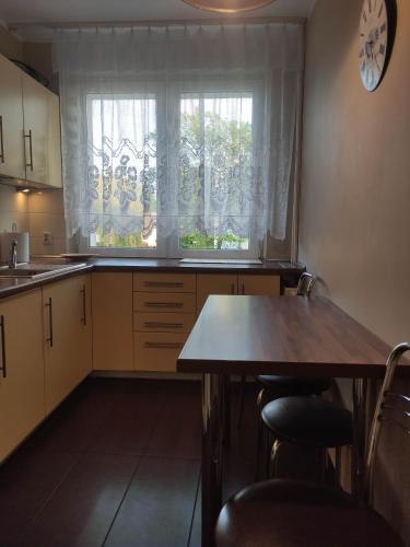 apartament beniowskiego في غدانسك: مطبخ مع طاولة خشبية ونافذة