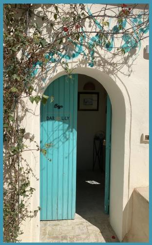 an archway with a blue door in a building at Dar Lily in Erriadh
