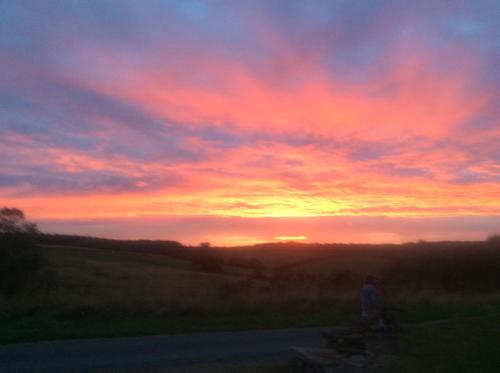 a person standing on a road in front of a sunset at Harvest End in York