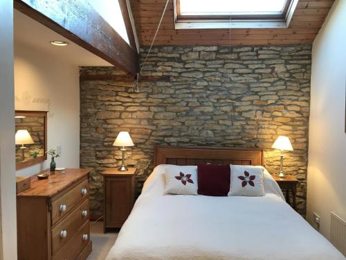 a bedroom with a bed and a stone wall at Harvest End in York