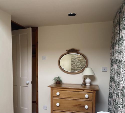 a bedroom with a dresser and a mirror on the wall at Harvest End in York