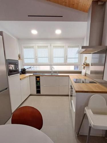a white kitchen with a sink and a counter at FeelhomeVIC. Ático con terraza en centro histórico in Vic