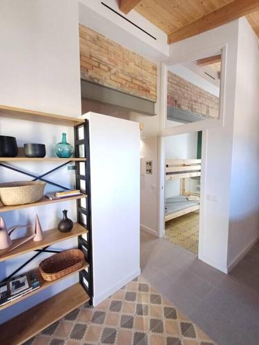 a room with an open door to a room with shelves at FeelhomeVIC. Ático con terraza en centro histórico in Vic