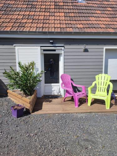 deux chaises assises sur une terrasse devant une maison dans l'établissement Belle chambre indépendante, à Sargé Les Le Mans 