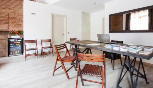 a room with a table with a laptop and chairs at BcnStop Parc Güell in Barcelona