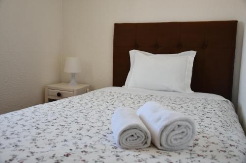 a bed with two towels on top of it at Alojamentos Vitinho - Vila Nova Milfontes in Vila Nova de Milfontes